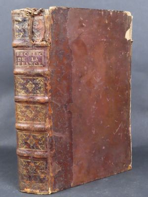 an old book sitting on top of a table next to a black background