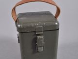 an old metal box with a leather handle on a white surface