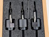 four pieces of drill bits in a wooden box on a white surface