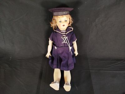 an old fashioned doll with a sailor outfit and hat on a black background