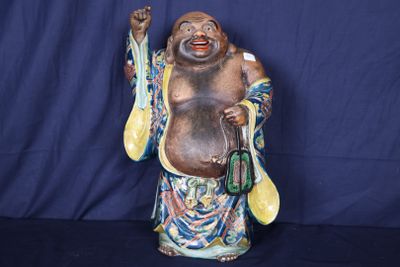 une statue représentant un homme qui rit, tenant une cuillère et une cuillère