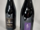 two bottles of wine sitting next to each other on a table