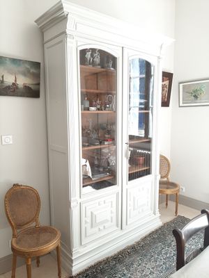 un vaisselier blanc dans un coin du salon