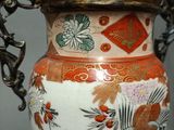 a vase with a handle that has a bird and flowers on it