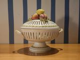un bol blanc sur lequel sont disposés des fruits, posé sur une table en bois