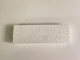 a piece of paper on a white surface next to a toothbrush