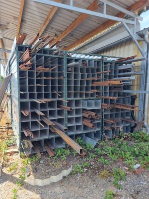 an image of a pile of metal pipes sitting on top of a dirt field