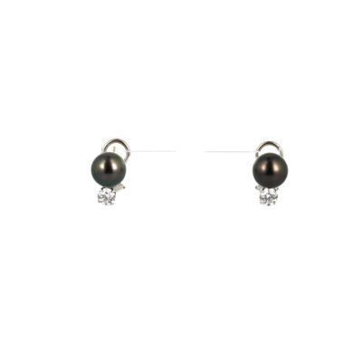 une paire de boucles d'oreilles en perles noires et diamants sur fond blanc