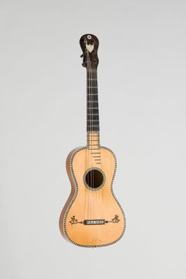une petite guitare en bois accrochée au mur