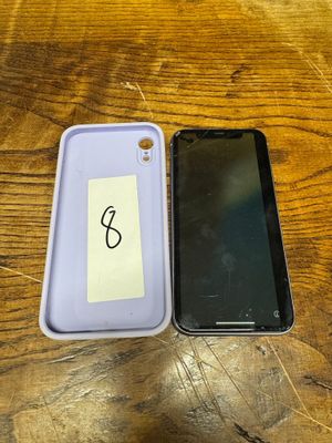 two cell phones are sitting on a wooden table with a note taped to the back of them