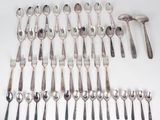 a lot of spoons and forks laid out on the table