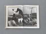 an open book with a black and white photo of a man and a woman sitting on a blanket