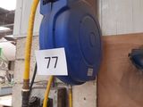 a blue hose attached to a wall next to a yellow hose