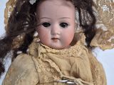 a close up of a doll wearing a hat and dress
