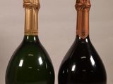 two bottles of champagne sitting next to each other on a table