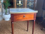 a small table with a marble top and wooden legs