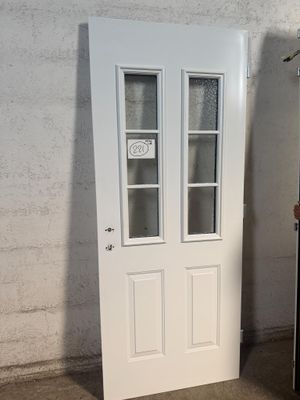 une porte blanche et un réfrigérateur noir dans une pièce