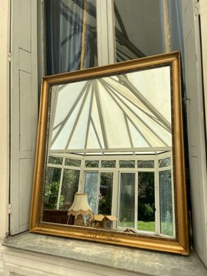 a mirror sitting on a window sill in front of a window