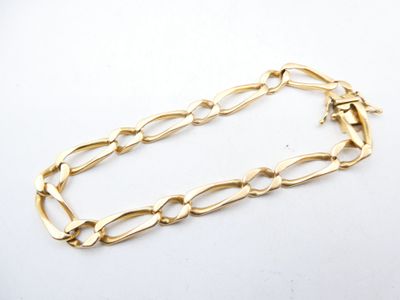 a close up of a gold chain bracelet on a white surface
