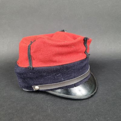 une image représentant un chapeau rouge et bleu posé sur une surface noire