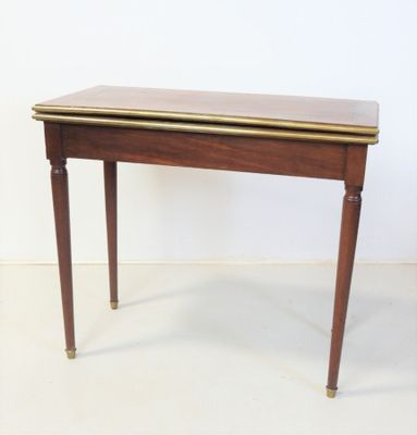 une petite table avec un plateau en bois et des finitions dorées