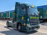 un camion vert garé devant un immeuble
