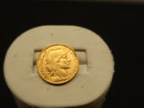 une pièce d'or posée sur un socle blanc