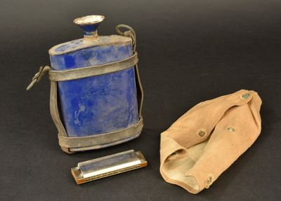 a blue bottle and a leather case on a black surface