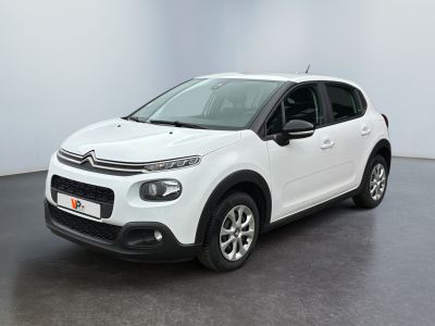 Une Citroën blanche est garée dans une pièce blanche