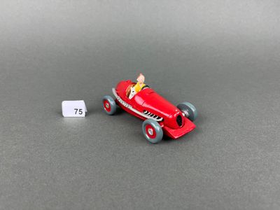a red toy car with a man in the driver ' s seat next to a white tag