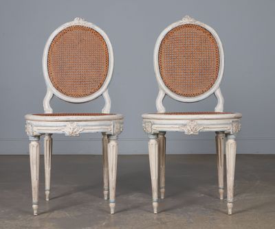 Paire de chaises cannées à dossier ovale, laquées crème et rechampies 