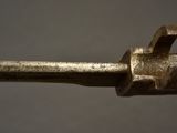 a close up of a metal object with a hammer on it
