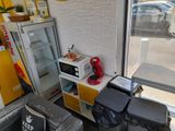 une petite cuisine équipée d'un micro-ondes, d'un réfrigérateur et de poubelles