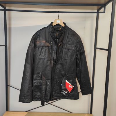 une veste en cuir noir accrochée à un porte-manteau dans une pièce