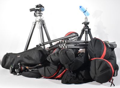 a lot of bags and a tripod sitting on the ground