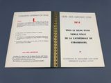 un livre ouvert posé sur une table bleue, avec une couverture rouge et blanche