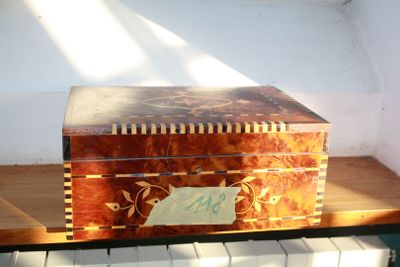 a wooden box sitting on top of a piano keyboard