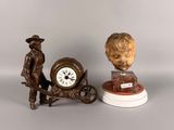 deux figurines représentant un homme et une horloge posées sur une table