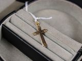une croix en or montée sur un anneau, dans un coffret noir