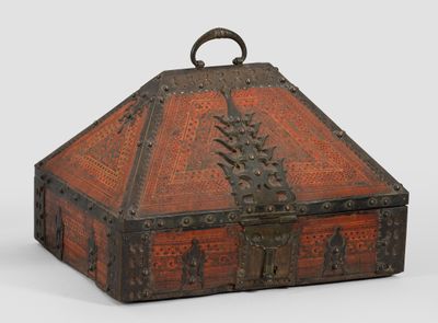une vieille boîte en bois munie d'une poignée métallique, posée sur une surface blanche