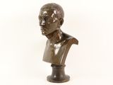 bronze bust of a man on a pedestal on a white background