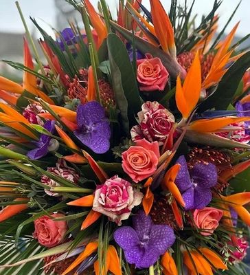 a bouquet of flowers on a table with a building in the background