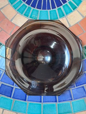 un bol en verre posé sur une table en mosaïque