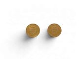 une paire de boucles d'oreilles à clous en forme de pièces d'or posées sur une surface blanche