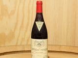 une bouteille de vin posée sur un tonneau