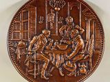 une image représentant une plaque de cuivre sur laquelle figurent un homme et une femme en train de jouer aux cartes