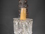 an antique wall sconce with a glass candle holder on a black background