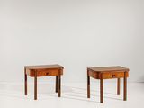 two small tables with drawers on each side of them in a white room