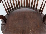 a wooden chair that is sitting on a white surface