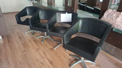 three black chairs sitting in a row in front of a mirror